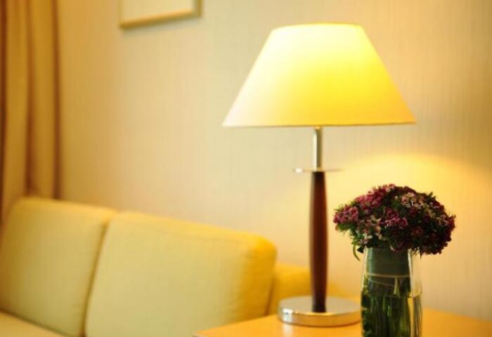 Bishop Lei International House room detail: table lamp, flowers, and sofa. A gay-friendly hotel offering comfort for travelers.