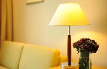 Bishop Lei International House room detail: table lamp, flowers, and sofa. A gay-friendly hotel offering comfort for travelers.