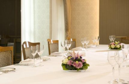Bishop Lei International House dining. Table setting with flowers, wine glasses, and white tablecloth. Gay-friendly hotel in Hong Kong.
