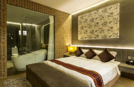 Bliss Hotel Singapore room. Gay-friendly hotel with a bedroom featuring a king-size bed and a bathroom with a modern bathtub. Asian-inspired decor.