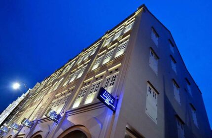 Exterior of Bliss Hotel Singapore, a gay-friendly hotel, at night. Building facade with illuminated windows and signage. Ideal for gay travel.