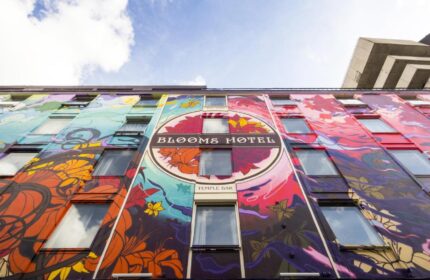 Exterior of Blooms Hotel, a gay-friendly hotel in Temple Bar, Dublin. Colorful floral mural on the building's facade.