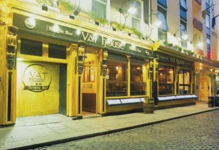 Blooms Hotel, a gay-friendly hotel, features the Vat House Bar in Temple Bar, Dublin. The bar's exterior is illuminated at night.