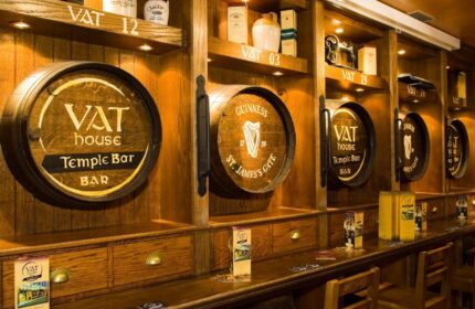 Blooms Hotel's gay-friendly bar, Dublin. Wooden barrels display VAT House Temple Bar and Guinness St. James's Gate. A traditional Irish pub.