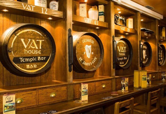 Blooms Hotel's gay-friendly bar, Dublin. Wooden barrels display VAT House Temple Bar and Guinness St. James's Gate. A traditional Irish pub.