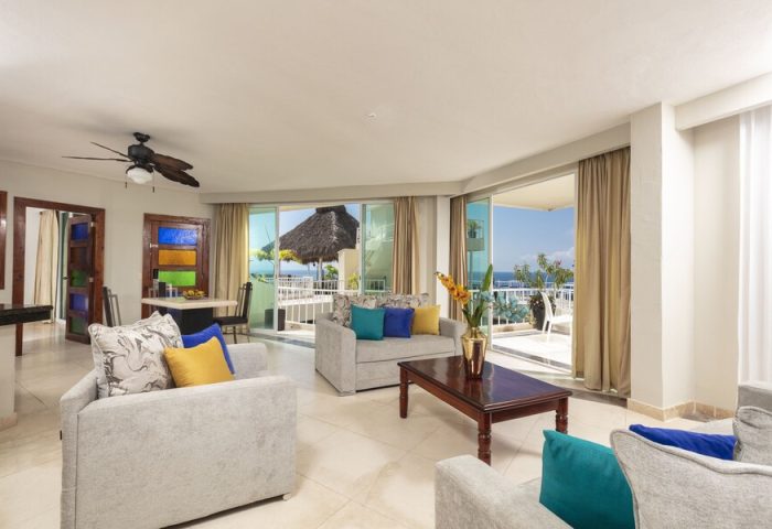 Living area at the gay-friendly Blue Chairs Resort by the Sea, an adults-only hotel. Balcony view of the ocean. Modern, bright interior.