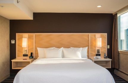 Blue Horizon Hotel gay-friendly room. King bed with white linens, wood headboard, bedside tables, lamps, and city view. Modern, comfortable.