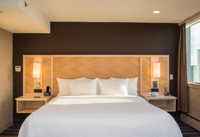 Blue Horizon Hotel gay-friendly room. King bed with white linens, wood headboard, bedside tables, lamps, and city view. Modern, comfortable.