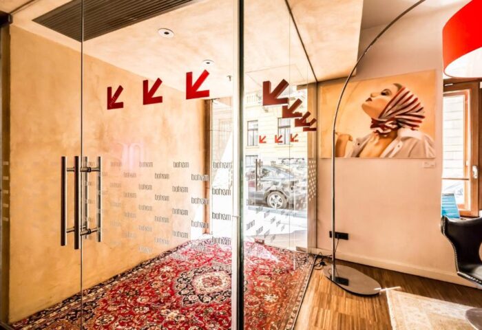Bohem Art Hotel entrance. Glass doors with Bohem text, red arrows, and a patterned rug. Gay-friendly hotel interior with artwork.