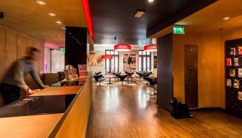 Bohem Art Hotel's lobby, a gay-friendly hotel. View of the reception desk and lounge area. Modern design with red accents. Ideal for gay travel.