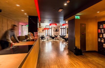 Bohem Art Hotel's lobby, a gay-friendly hotel. View of the reception desk and lounge area. Modern design with red accents. Ideal for gay travel.