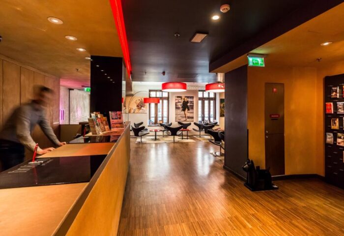Bohem Art Hotel's lobby, a gay-friendly hotel. View of the reception desk and lounge area. Modern design with red accents. Ideal for gay travel.