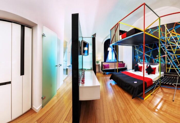 Bohem Art Hotel room. Gay-friendly hotel with a unique design, featuring a bed with colorful geometric frame and a modern interior.