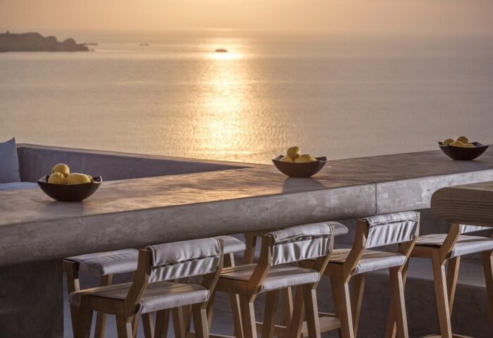 Sunset view from Boheme Mykonos Hotel, an adults-only, gay-friendly hotel. Bar stools and lemons overlooking the Aegean Sea. Mykonos travel.