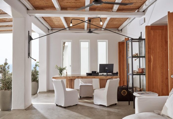 Boheme Mykonos Hotel Adults Only reception. Gay-friendly hotel design with white walls, wooden desk, and stylish decor. Luxury travel.