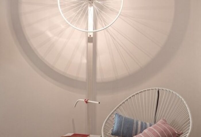 Boheme Mykonos Hotel adults-only detail. Modern interior with bike wheel light fixture, chair, and pillows. Gay-friendly hotel design.