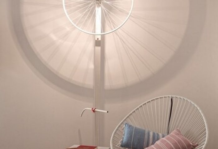 Boheme Mykonos Hotel adults-only detail. Modern interior with bike wheel light fixture, chair, and pillows. Gay-friendly hotel design.