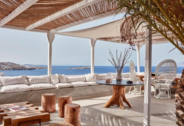 Boheme Mykonos Hotel adults-only gay-friendly resort terrace view. Seating area with sea view. Mykonos travel destination.