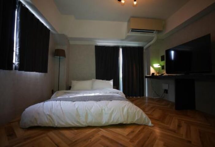 Book Tea Bed SHINJUKU-GYOEN gay-friendly hotel room. Bed with white linens, TV, wood floors. Modern, comfortable stay for gay travelers.