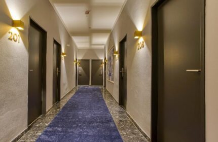 Hallway at Boutique Hotel 026 Köln St. Michael, a gay-friendly hotel. Blue carpet, room numbers, and modern design. Köln gay travel advice.