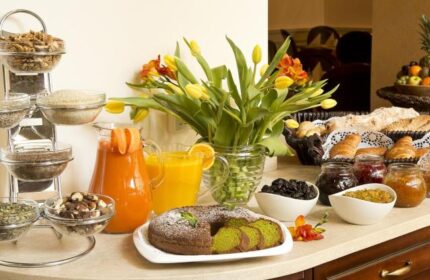 Breakfast buffet at Gay-Friendly Boutique Hotel Seven Days. Juices, cake, cereals, bread, croissants, jams, and fruit. Gay travel advice.