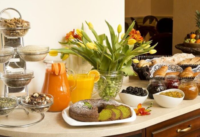 Breakfast buffet at Gay-Friendly Boutique Hotel Seven Days. Juices, cake, cereals, bread, croissants, jams, and fruit. Gay travel advice.