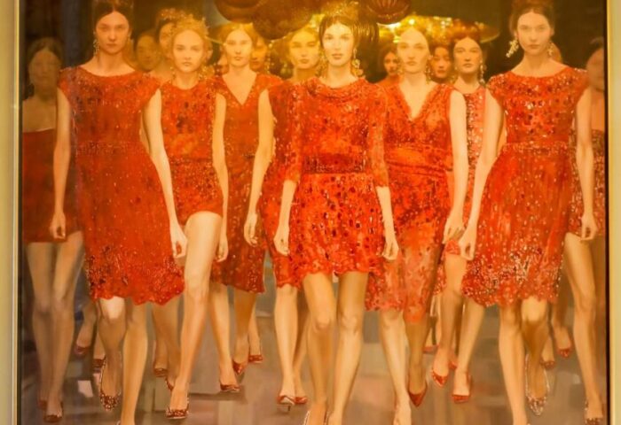 Gay-Friendly Boutiquehotel Das Tyrol: Art detail with a painting of women in red dresses under a golden chandelier, plus a red sofa.