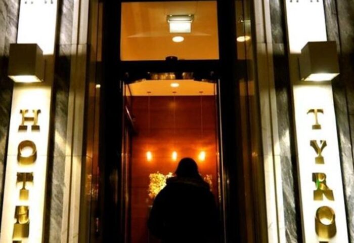 Entrance to Boutiquehotel Das Tyrol, a gay-friendly hotel. Person entering. HOTEL TYROL signage. Gay travel lodging advice.
