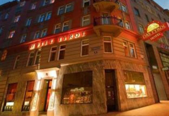 Exterior of Boutiquehotel Das Tyrol, a gay-friendly hotel. The building's facade is lit, showcasing its architecture in Vienna.