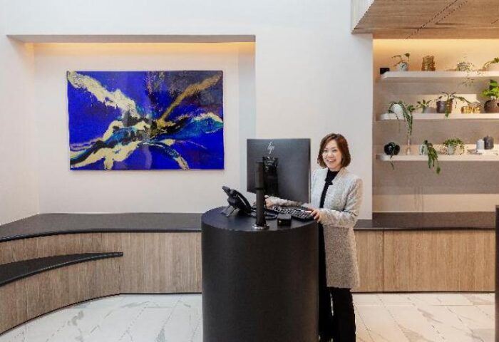 Brady Hotels Jones Lane reception. Woman at desk, modern design. Gay-friendly hotel with stylish decor, plants, and art. Travel advice.