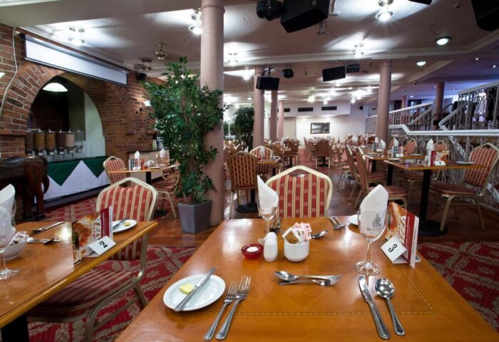 Britannia Manchester Hotel dining area. Gay-friendly hotel with tables set for dining, striped chairs, and a buffet area. Ideal for gay travel.
