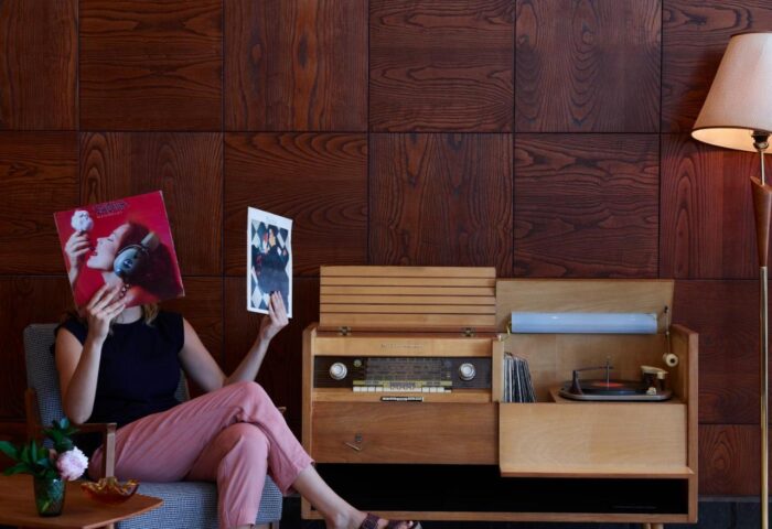 Brown Acropol Hotel: Woman with records by vintage radio. Gay-friendly hotel interior, part of Brown Hotels collection.