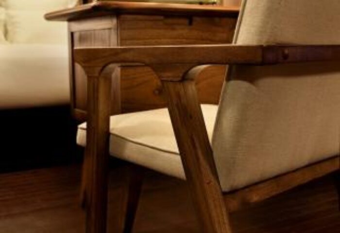 Brown TLV Hotel detail: wooden chair, desk, and floor in a room at the gay-friendly hotel. Ideal for gay men's travel to Tel Aviv.