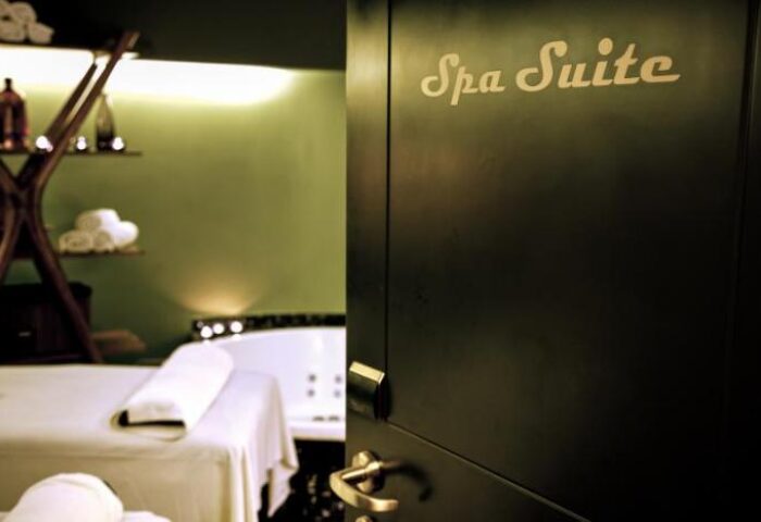 Spa Suite at Brown TLV Hotel, a gay-friendly hotel. Doorway view of massage table and jacuzzi tub. Relaxation and wellness for gay travelers.