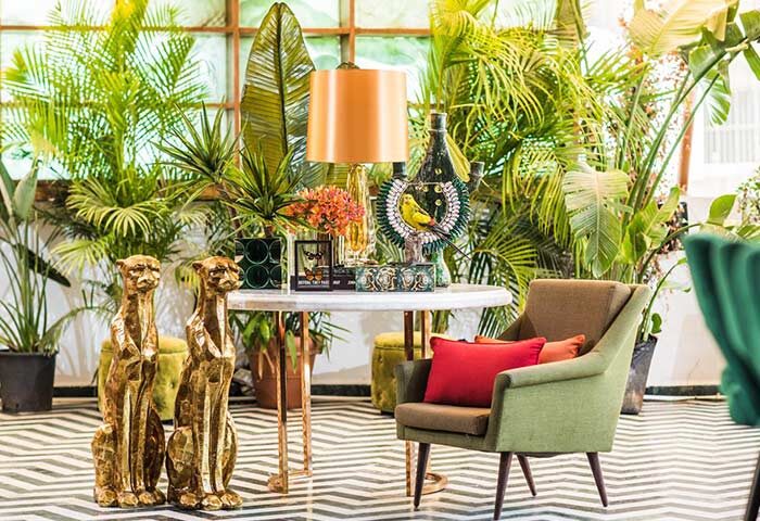 Lobby interior at Brown TLV Hotel, a gay-friendly hotel in Tel Aviv. Lush plants, cheetah statues, and stylish decor create a vibrant atmosphere.