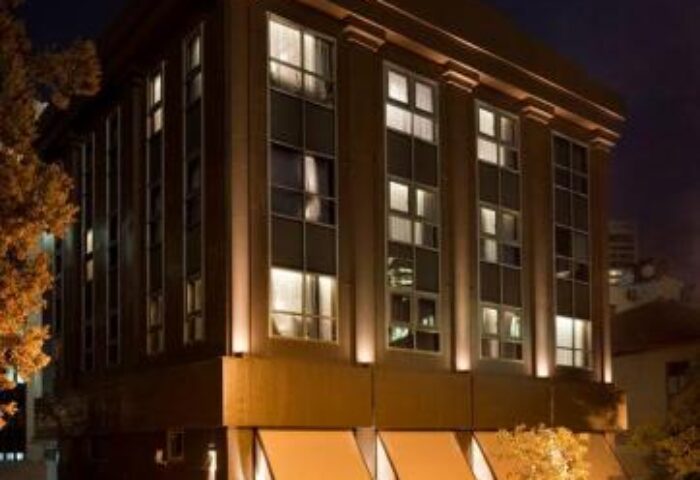 Brown TLV Hotel exterior at night. Gay-friendly hotel in Tel Aviv, Israel, with modern facade and awnings. Ideal for gay men's travel.