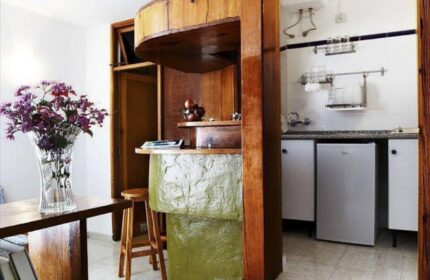 Bungalows Tenesoya Gay Men Only hotel room. Kitchenette with a bar, fridge, and sink. Gay-friendly hotel interior design.