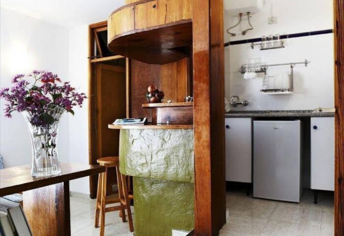 Bungalows Tenesoya Gay Men Only hotel room. Kitchenette with a bar, fridge, and sink. Gay-friendly hotel interior design.