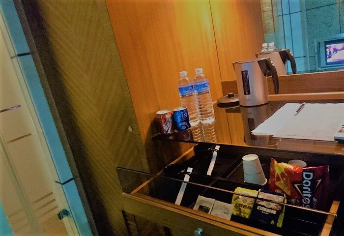 Burgary Hotel gay-friendly room: snacks, water bottles, and kettle on a wooden desk. Travel advice for gay men. Hotel room amenities.