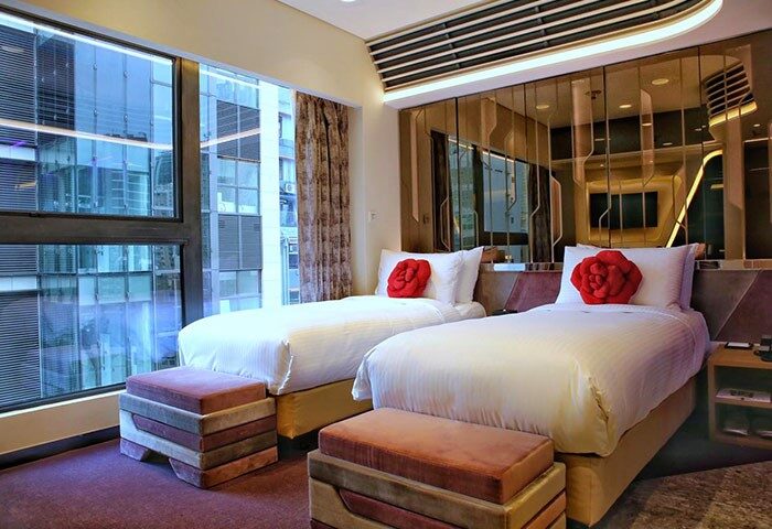 LKF Boutique Hotel Central room. Gay-friendly hotel with twin beds, rose pillows, and a city view. Ideal for gay men travel in Hong Kong.