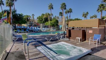 CCBC Resort Hotel pool and hot tub. Gay men's resort with lounge chairs, palm trees, blue skies. A gay-friendly hotel for your vacation.