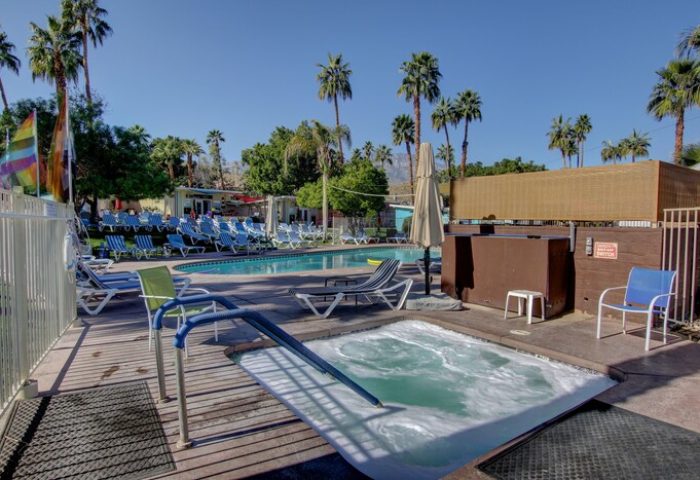 CCBC Resort Hotel pool and hot tub. Gay men's resort with lounge chairs, palm trees, blue skies. A gay-friendly hotel for your vacation.