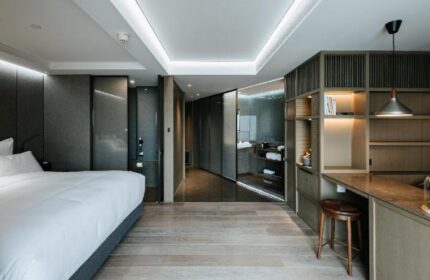 CHAO Sanlitun Beijing gay-friendly hotel room. Modern interior with bed, desk, stool, and bathroom. Stylish design for gay travelers.