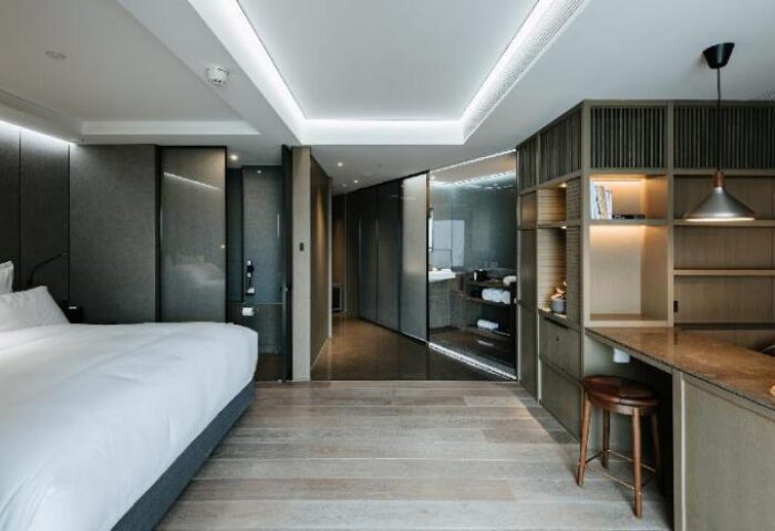 CHAO Sanlitun Beijing gay-friendly hotel room. Modern interior with bed, desk, stool, and bathroom. Stylish design for gay travelers.