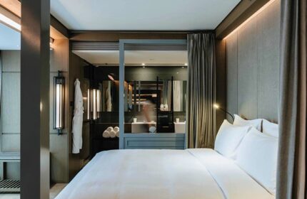 CHAO Sanlitun Beijing gay-friendly hotel room. View of the bed, bathroom with mirrors, and modern design. Best gay hotels in Beijing.