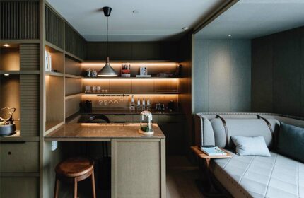 CHAO Sanlitun Beijing hotel room. Gay-friendly hotel with bar, shelves, stool, couch, and lighting. Modern design at this Beijing travel destination.