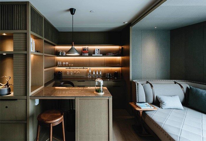 CHAO Sanlitun Beijing hotel room. Gay-friendly hotel with bar, shelves, stool, couch, and lighting. Modern design at this Beijing travel destination.