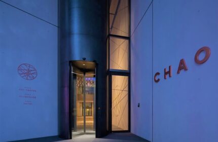 CHAO Sanlitun Beijing gay-friendly hotel entrance. Revolving door, art center logo, and the hotel name on the building's facade.