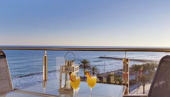 Hotel Calipolis, a gay-friendly hotel: Balcony view with cocktails overlooking the sea. Perfect for gay men's travel and a relaxing vacation.