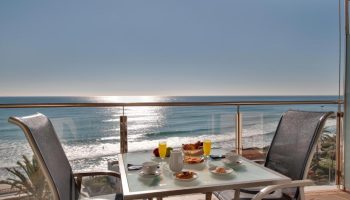 Breakfast with a view at Hotel Calipolis, a gay-friendly hotel. Ocean view from balcony with table set for two. Perfect for gay travel.